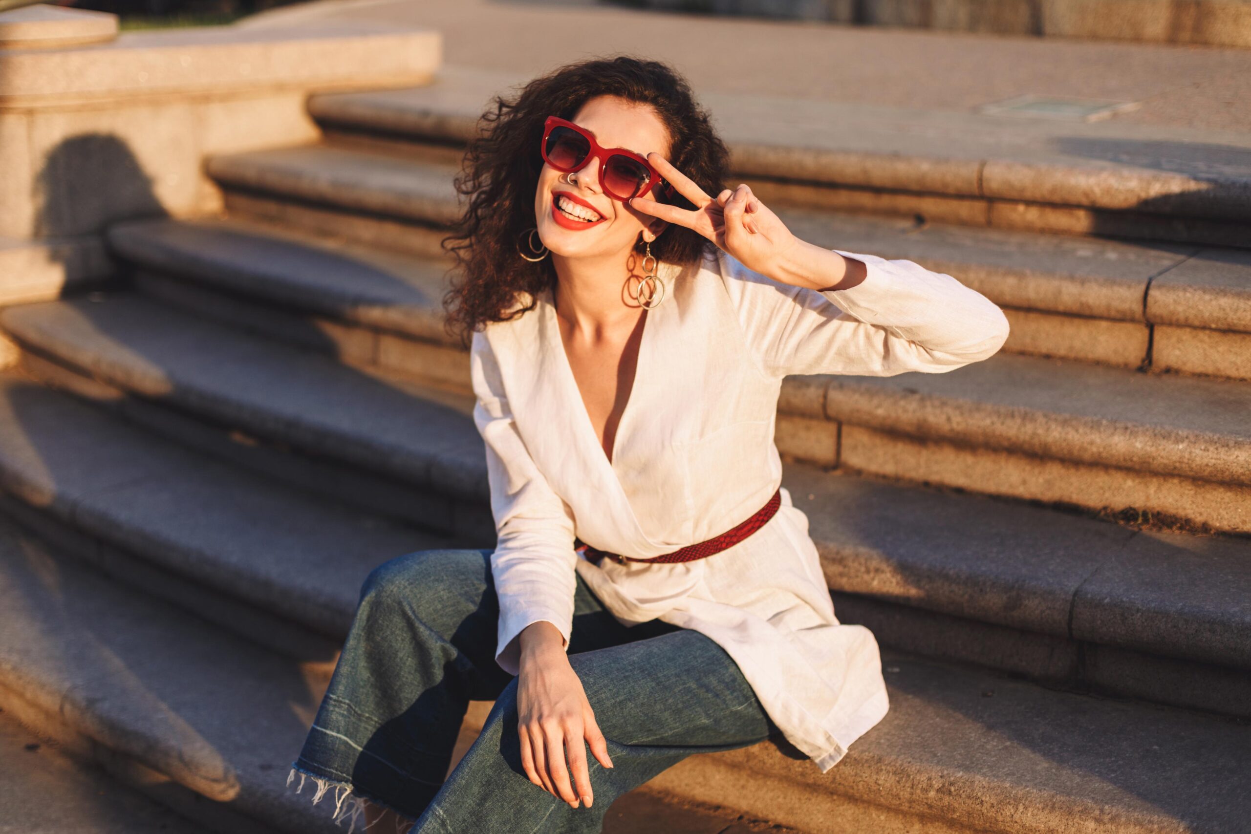 młoda kobieta w okularach siedząca nas chodach