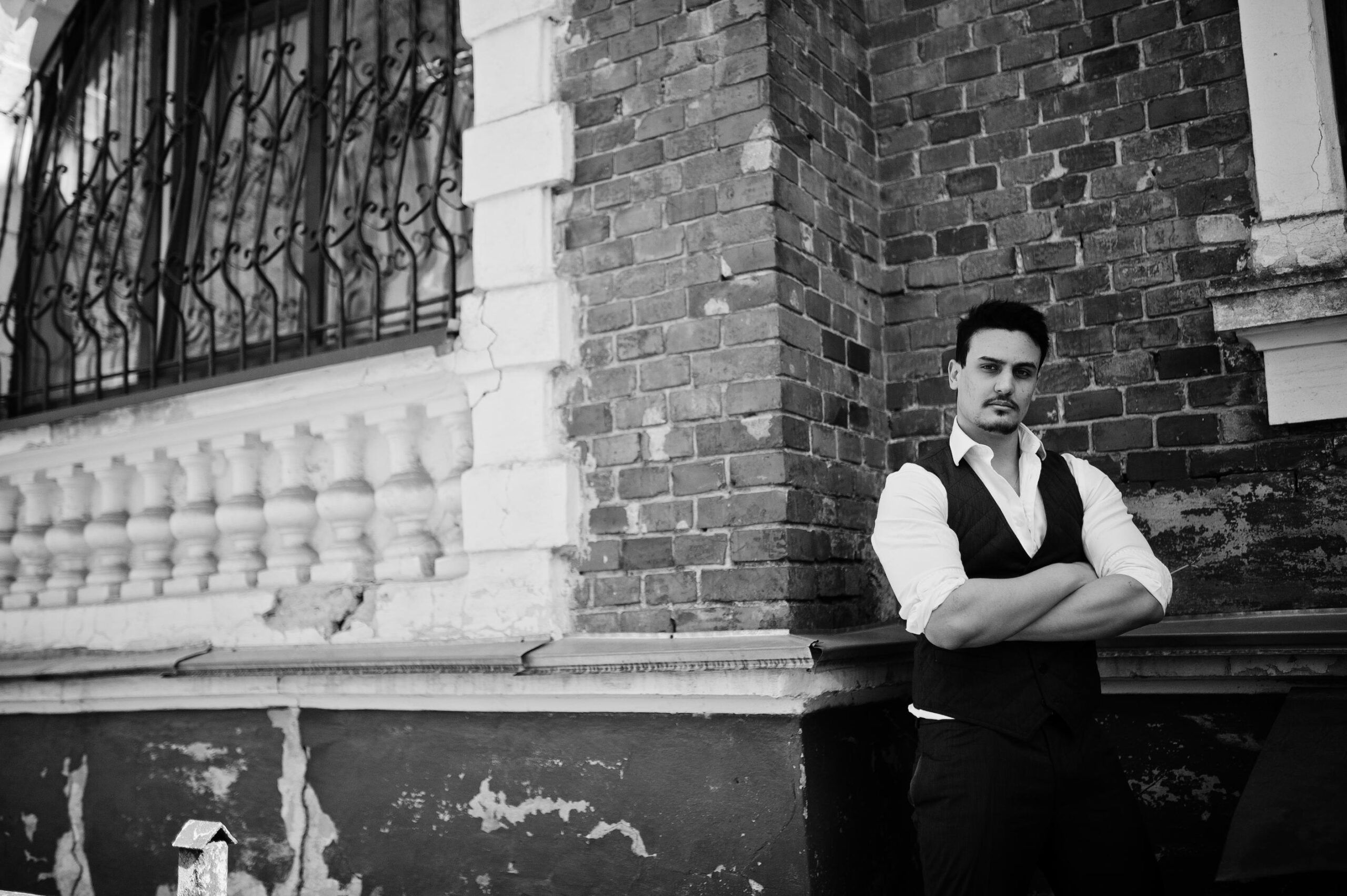 młody mężczyzna ubrany w białą koszulę i kamizelkę